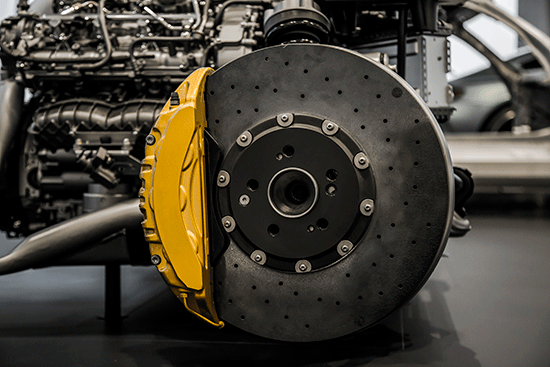 yellow disc brake with car parts in the background